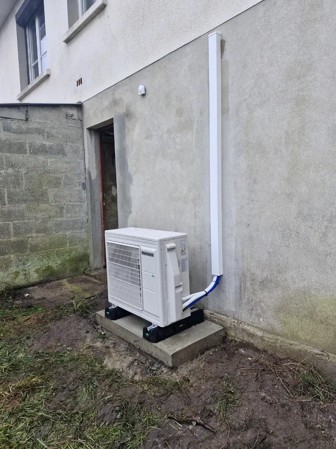 Unité extérieure de pompe à chaleur installée au pied d’une maison