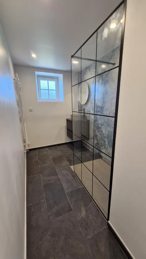 Espace douche avec paroi vitrée à montants noirs
